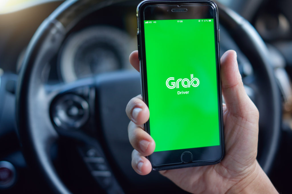 grab car driver holding smartphone with grab driver app