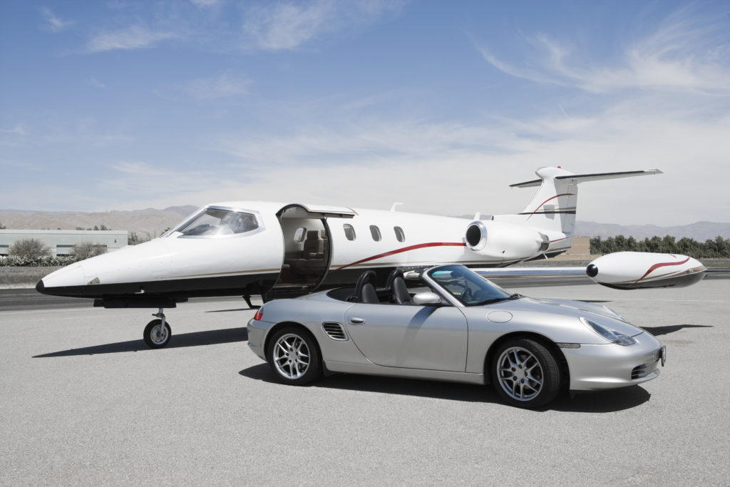 Porsche 911 parked in front of a jet