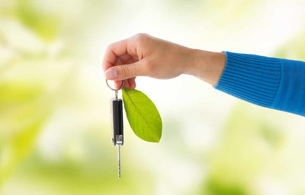 car key attached to a leaf that represents environmental friendly hybrid cars for private hire