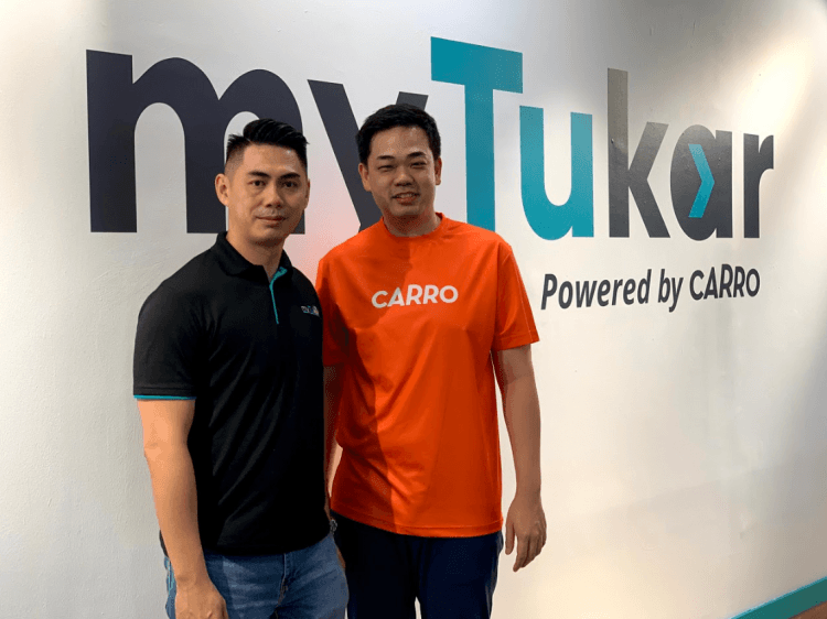 Carro and MyTukar CEOs in front of a MyTukar logo
