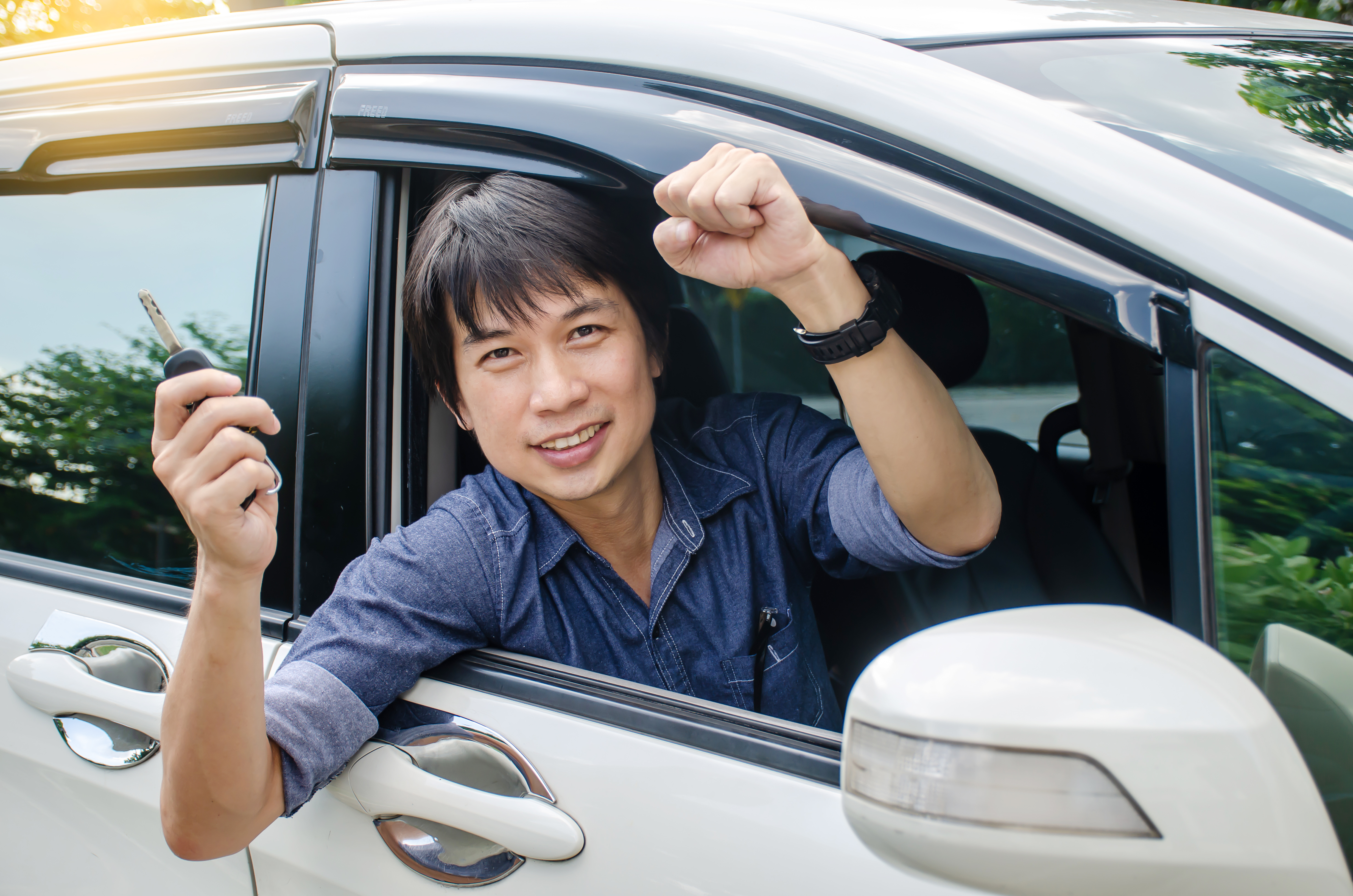 happy asian man driving after he rent a car in Singapore