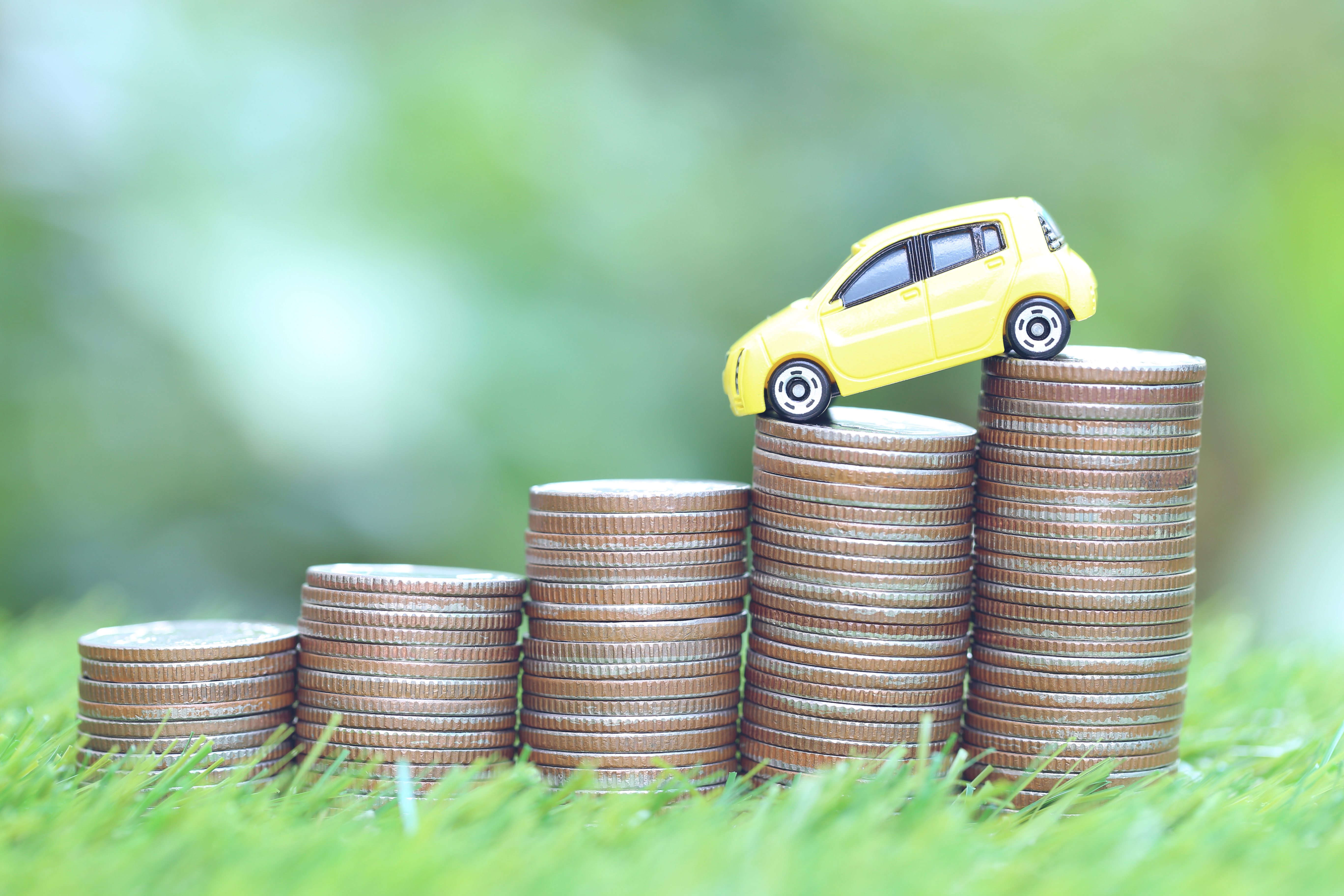 car on a stack of coins to show how it depreciates