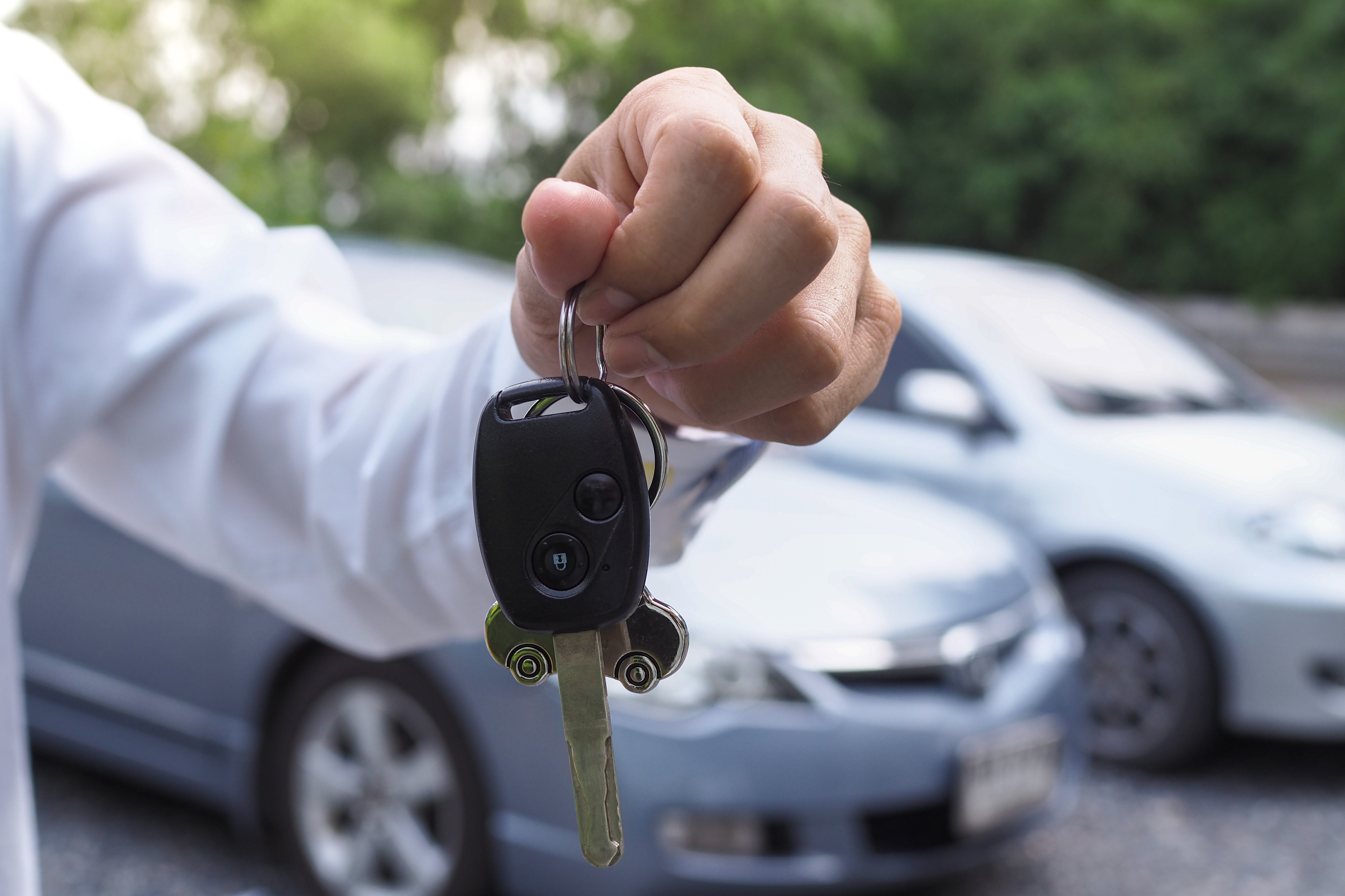 man holding car keys in front of car