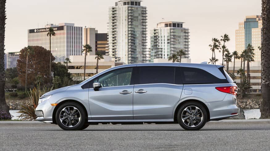 Honda Odyssey driving by skyscrapers