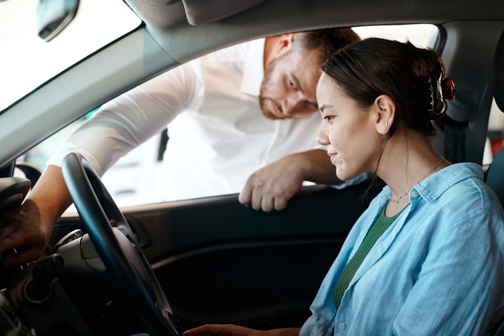 Car dealer shows woman car dashboard